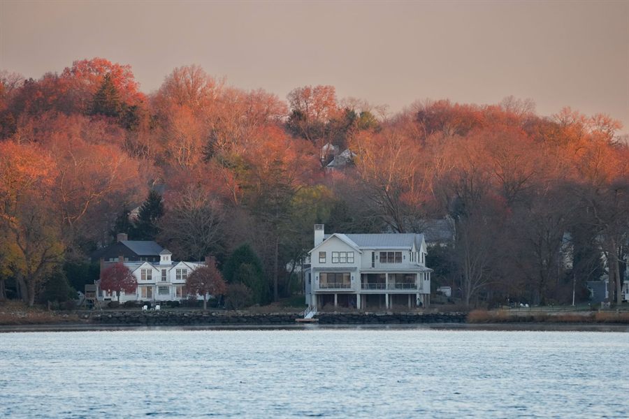 Autumn color behind waterfront houses on the New England coast
